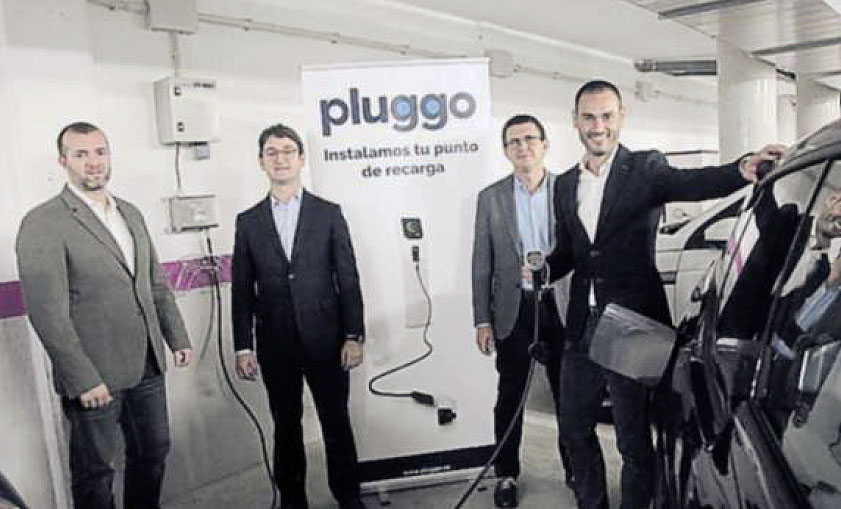 Los fundadores de Pluggo con un punto de recarga de coche eléctrico